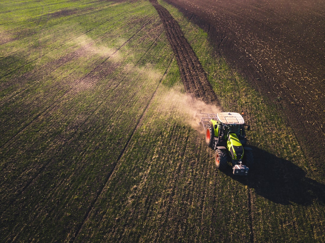 green and white tractor on green grass field